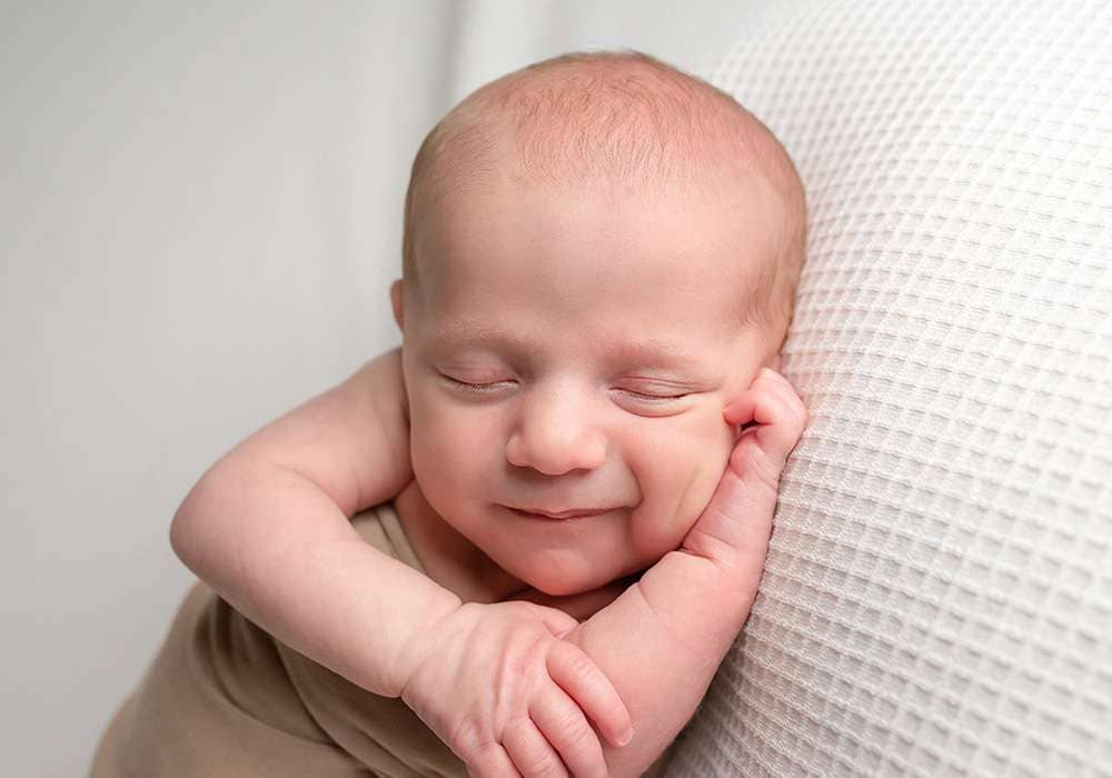 smiling newborn baby during professional baby photoshoot in west sussex