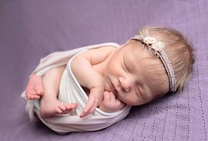 image of baby girl in floral headband west Sussex newborn photographer