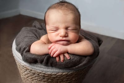 baby resting head in hands by west sussex baby photography