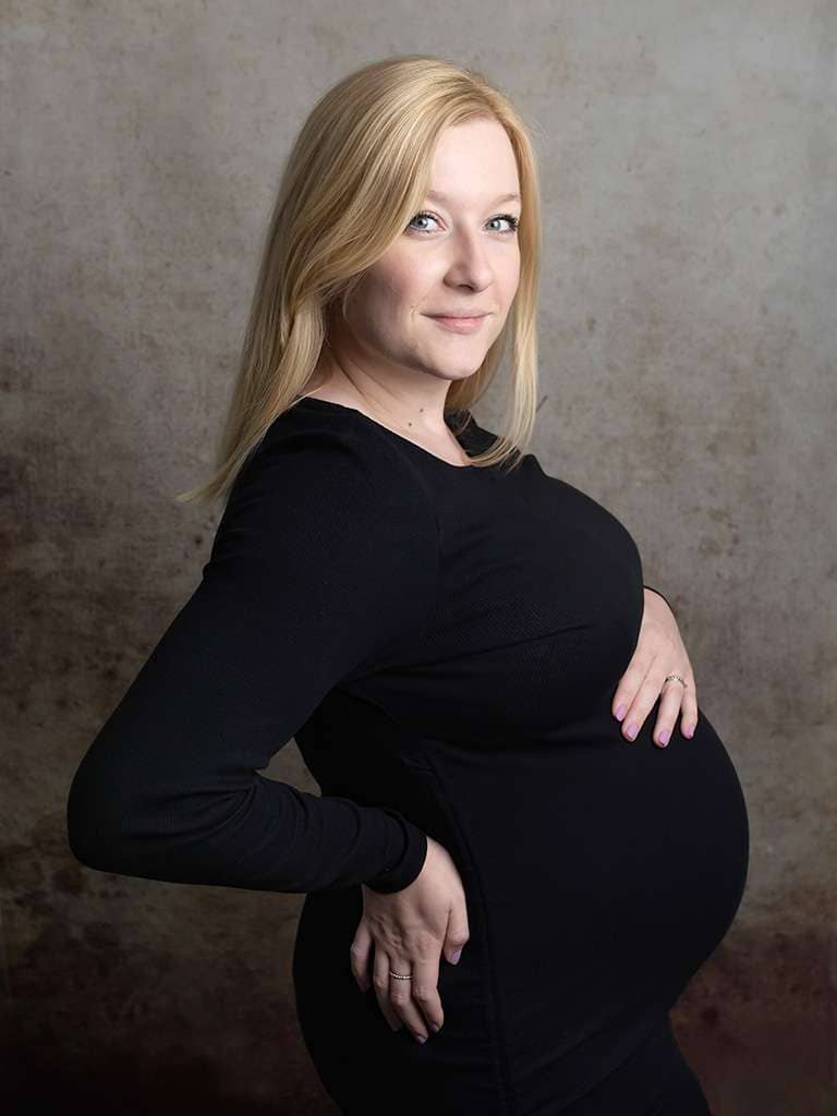 pregnant woman in black dress photographer in West Sussex studio