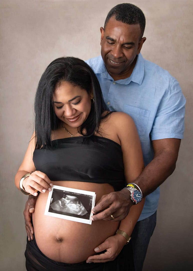 pregnant woman of colour wearing gold long gown taken by Burgess Hill maternity photographer