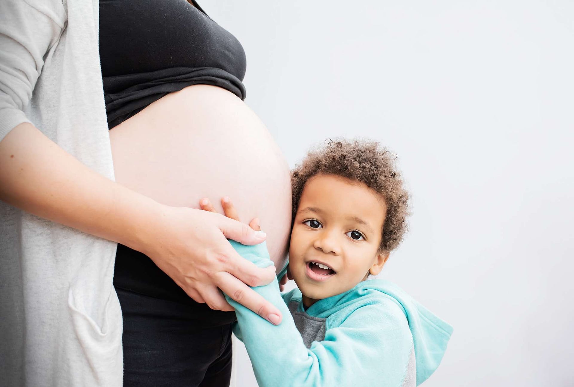 Pregnancy Bump and boy listening to baby taken by pregnancy photographer in West Sussex